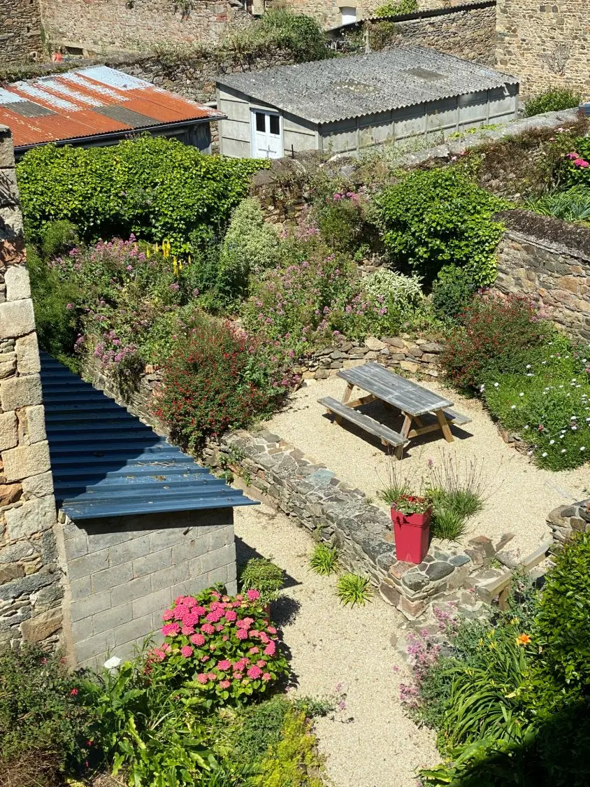 Côté cour, le jardin fleuri avec sa table de pique-nique